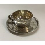 A Continental silver miniature teacup and saucer.