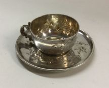 A Continental silver miniature teacup and saucer.