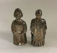 A pair of Chinese silver peppers depicting a relig