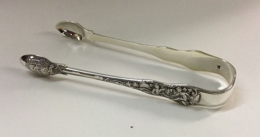 A heavy pair of cast silver sugar tongs. London. A