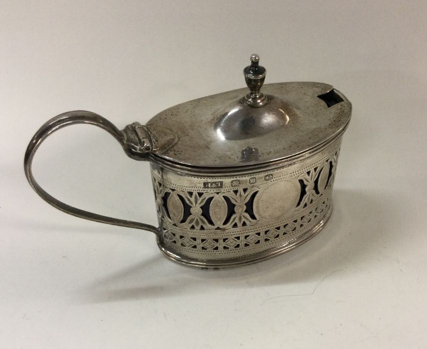 A silver pierced mustard pot and spoon. Birmingham