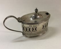 A silver pierced mustard pot and spoon. Birmingham
