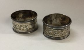 A pair of silver napkin rings with floral engraved