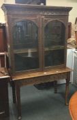 A carved oak bookcase on matching base.