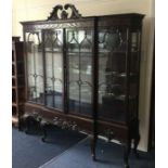 A massive mahogany break front cabinet with scroll