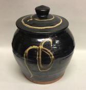A dark brown glazed earthenware pottery lidded jar