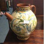 A large pottery jug decorated with stylised flower