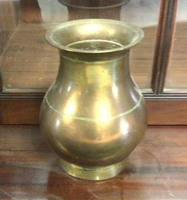 A heavy brass vase of Oriental design.