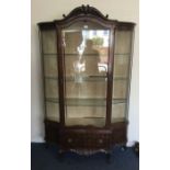 A good shaped front display cabinet on scroll feet