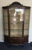A good shaped front display cabinet on scroll feet