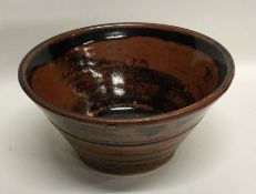 A tub shaped pottery bowl of tenmoku design. Signe