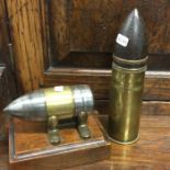 A brass mounted bullet together with one other.