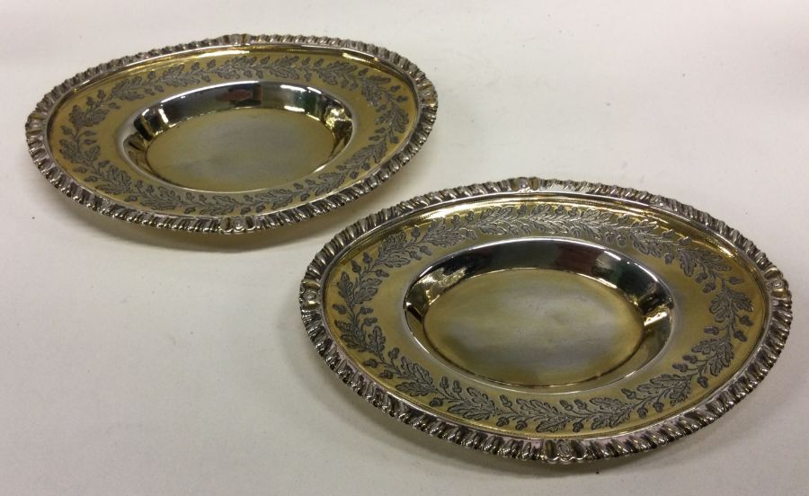 A fine pair of George III silver gilt dishes engra