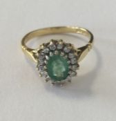 A large emerald and diamond cluster ring in 18 car