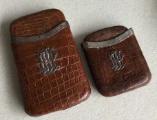 Two crocodile skin cigar cases with silver mounts.