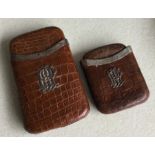 Two crocodile skin cigar cases with silver mounts.