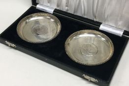 A cased set of silver dishes inset with coins. App