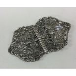A decorative pair of silver buckles with floral en
