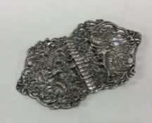 A decorative pair of silver buckles with floral en