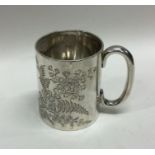 A silver christening mug engraved with leaves. She