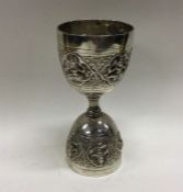 A Continental silver shot measure with chased deco