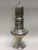 A large chased silver sugar caster with half flute