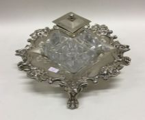 A heavy Victorian silver and glass inkwell on feet