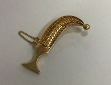 A high carat gold brooch in the form of a dagger.