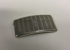 A slim shaped silver card case with engine turned