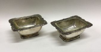 A decorative silver pair of salts with shell borde