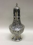 A good chased silver sugar caster with floral moun