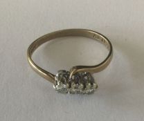 A small diamond three stone cross over ring in 9 c