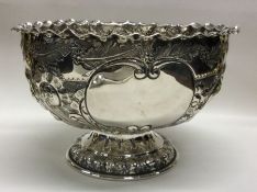 A heavy embossed silver rose bowl with crimped rim