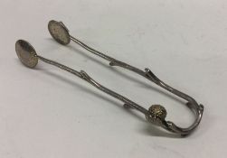 A pair of silver tongs with strawberry decoration