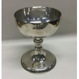 A heavy silver communion goblet with stand. London