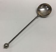 A large oversized silver serving spoon with spiral