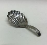 A William IV silver caddy spoon with fluted bowl.