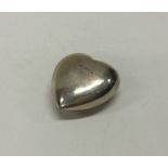 A heavy silver paperweight in the form of a heart.