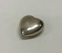 A heavy silver paperweight in the form of a heart.