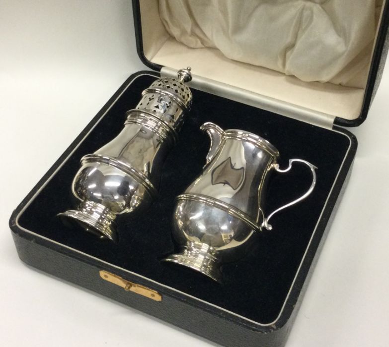 A good cased silver sugar caster together with mat