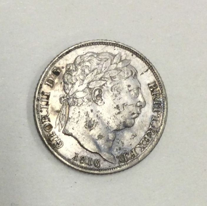 A George III Sixpence dated 1816.