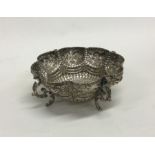 A chased silver pin dish with embossed decoration.