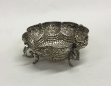 A chased silver pin dish with embossed decoration.