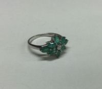 An emerald and diamond cluster ring. Approx. 3 gra