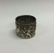 A large silver napkin ring decorated with figures.