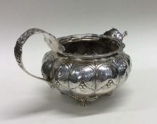 A George III chased silver cream jug. London 1825.