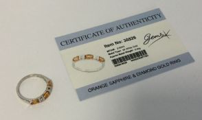 An orange sapphire and diamond ring set in 9 carat