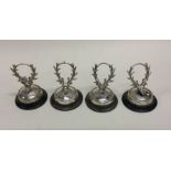 A set of four silver menu holders in the form of d