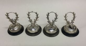A set of four silver menu holders in the form of d