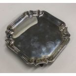 A square silver salver with decorative border. By